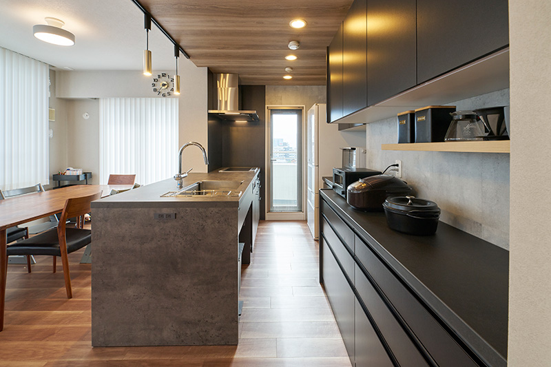 温かみのある木目天井とシックなグレーのキッチン