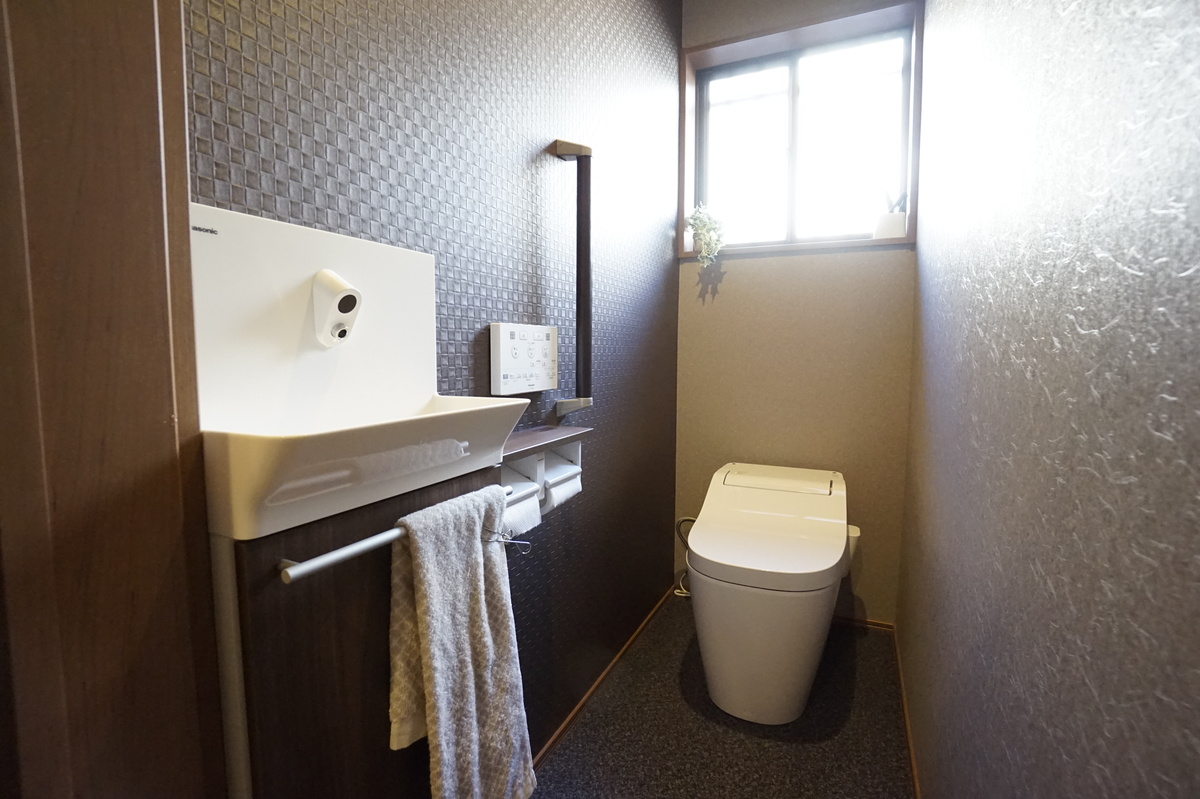 黒の壁が映えるモダンなトイレ空間