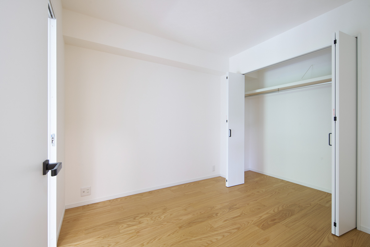 白い壁と木目、収納のある明るい洋室