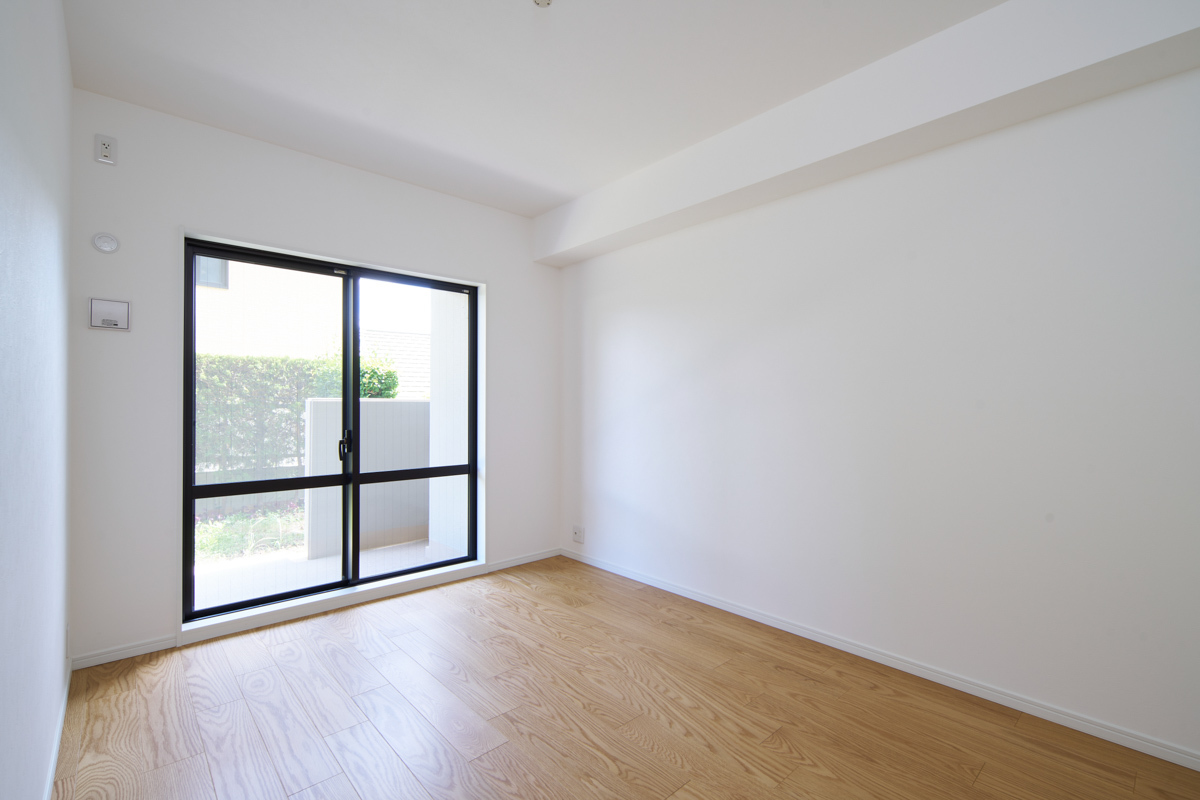 大窓から光入る、白と木目の明るい部屋