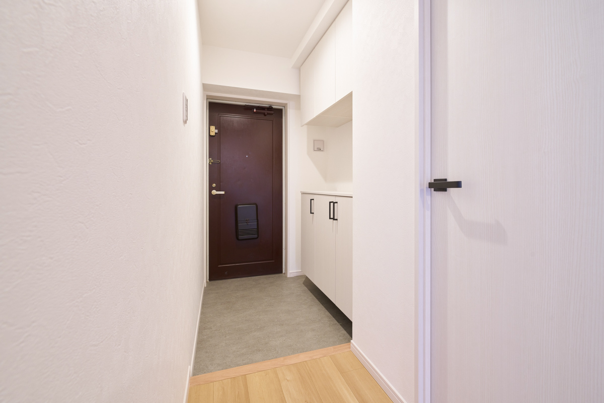 濃茶の扉が映える、清潔な白い玄関