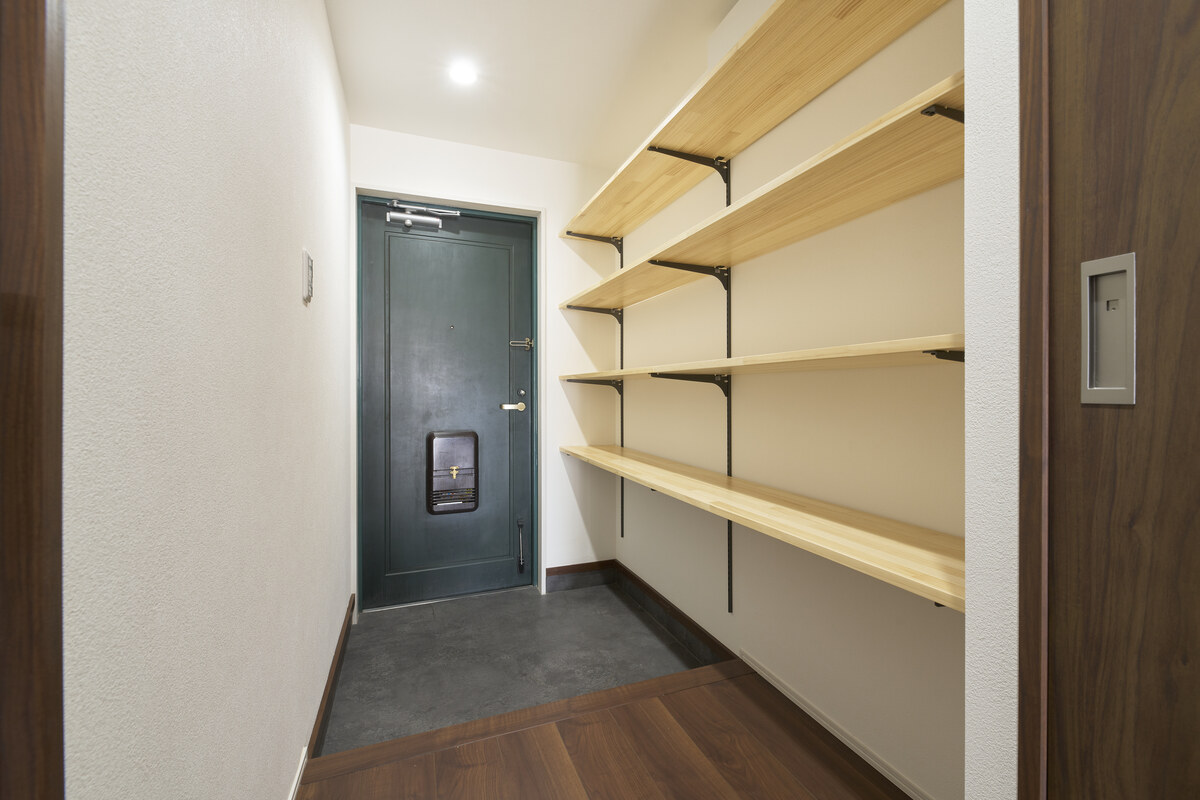 深緑の扉と木目棚の、機能的な玄関