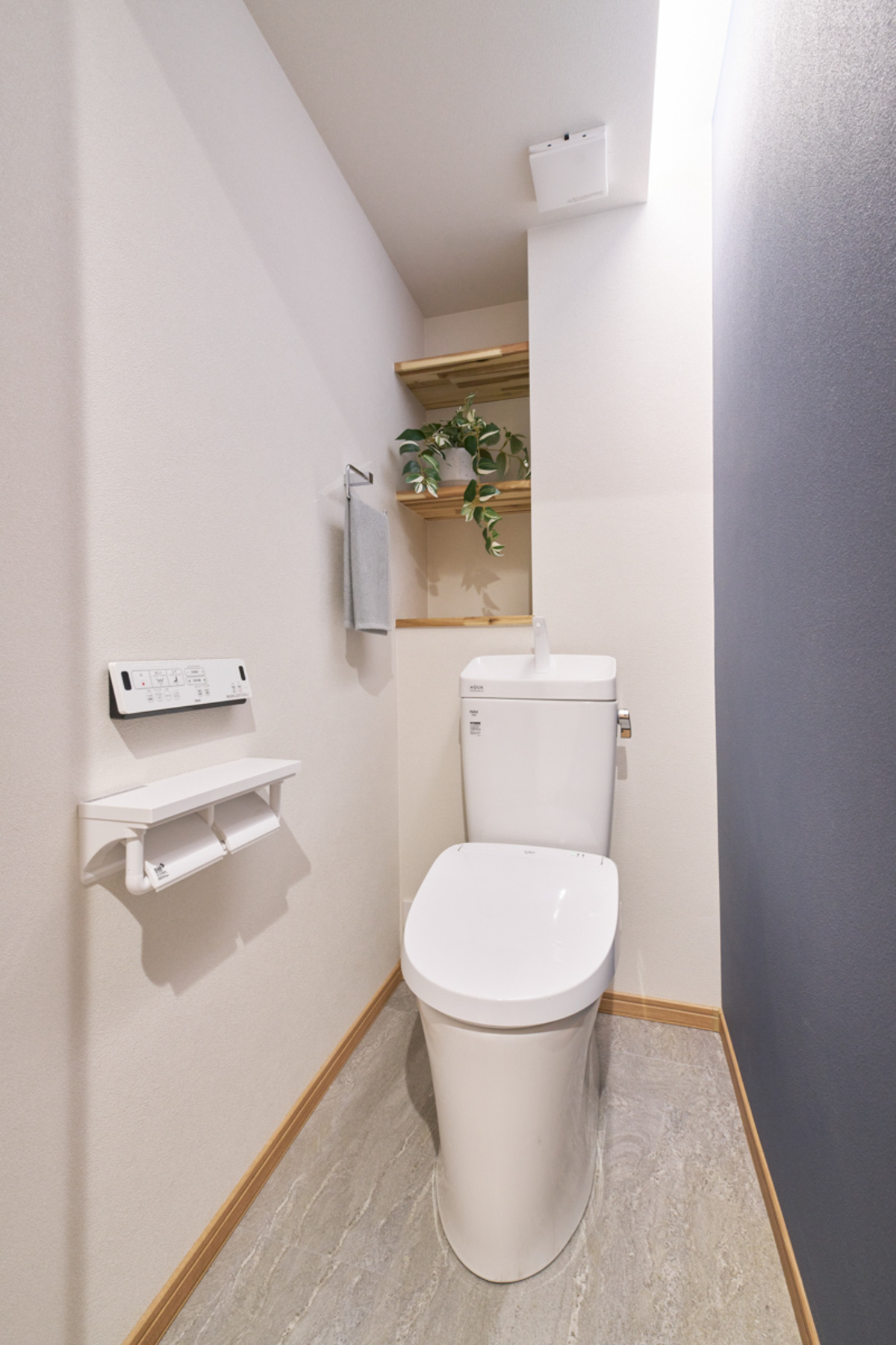 紺のアクセント、清潔な白いトイレ