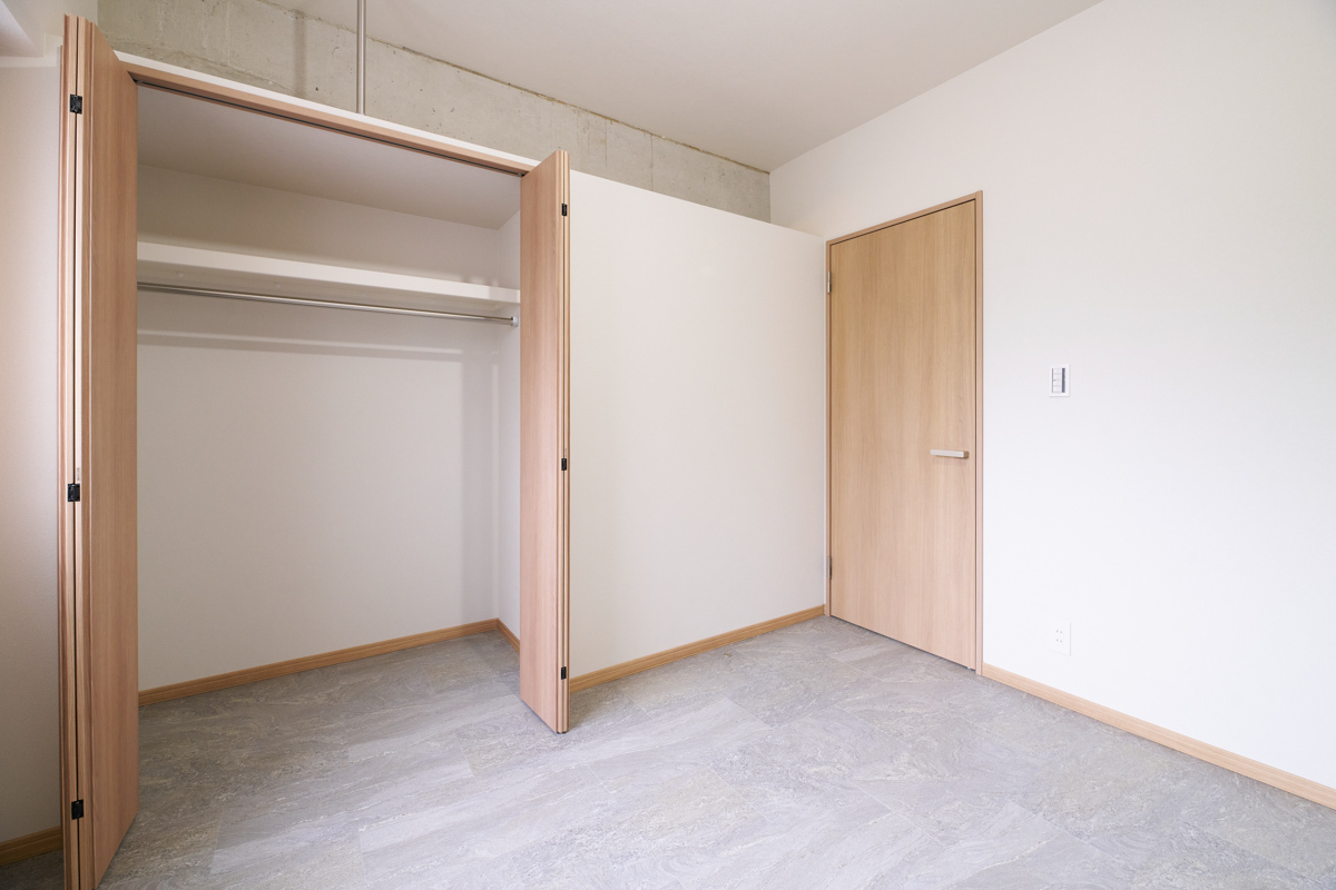濃木目扉が開いた、グレー床の収納
