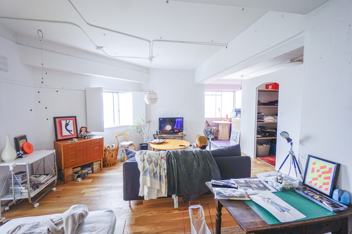 アートと木製家具が並ぶ、白いアトリエ