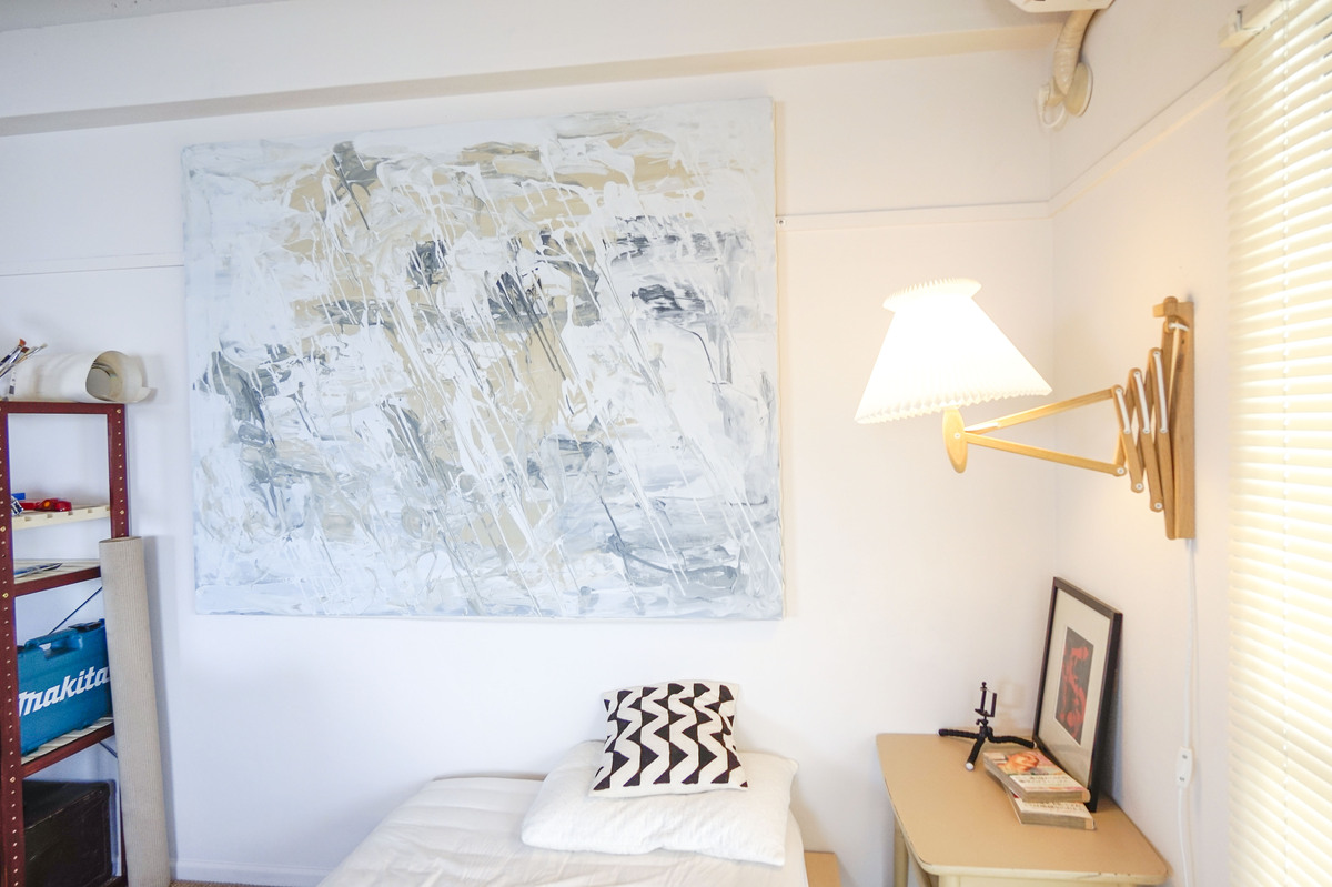 白壁に映える大判アートと、木のランプ