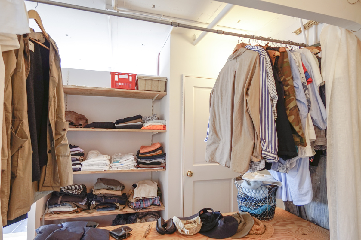 衣類並ぶ木棚と、機能的な吊り収納