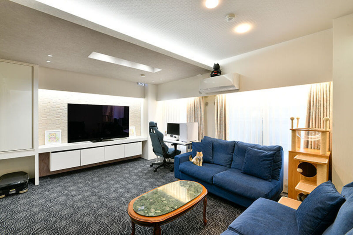 白い大収納と紺ソファの明るいリビング