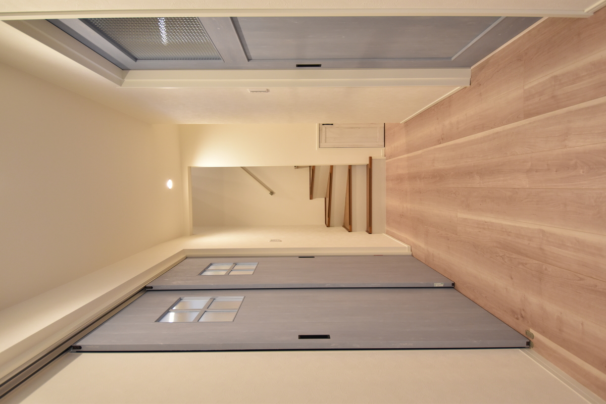 青い扉が並ぶ、木の温もりある廊下