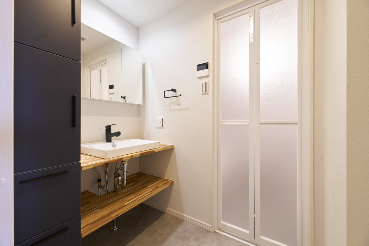 木目と紺が映える清潔な洗面室			