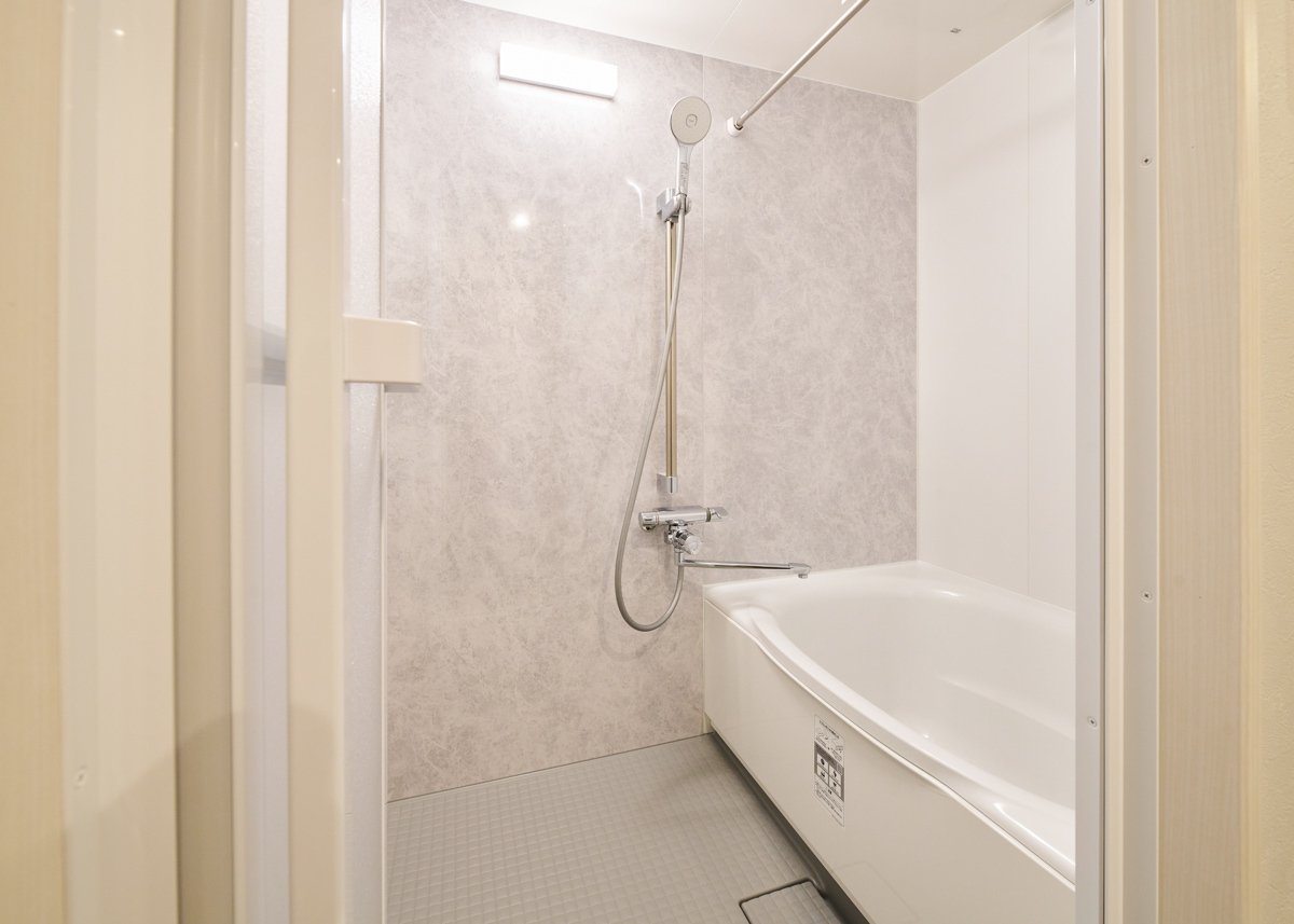 グレー石目壁が落ち着く清潔な浴室			