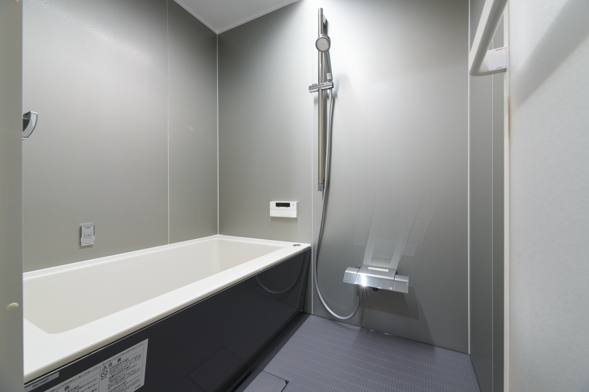 シックなグレー壁と黒い浴槽の浴室			